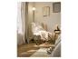 Beige fauteuil met kussen en deken, nachtkastje met lamp en schilderijen aan de muur.