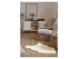 Salon moderne avec fauteuil, buffet, tapis en fausse fourrure et plante.