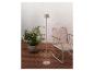 Lampadaire beige et chaise d'extérieur sur une terrasse en bois avec une plante.