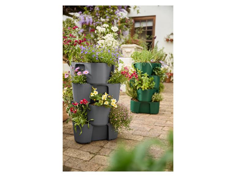 Twee verticale tuinsystemen met bloemen en planten in een tuin.