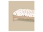 Drap blanc à motif pastèque sur un lit en bois.