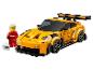 Voiture jouet jaune avec aileron et figurine de pilote avec casque.