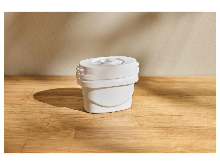 Wit waterfilter op een houten oppervlak met een beige muur op de achtergrond