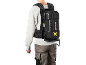 Homme portant un sac à dos avec une batterie d'outil et un pantalon de travail.
