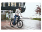 Een man fietst op een zwarte elektrische fiets in de stad.