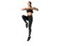 Femme en brassière de sport noire et leggings effectuant un exercice de levée de genou.
