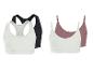 Twee sets dames sportbeha's: zwart en wit racerback, en wit en roze camisole-stijl.
