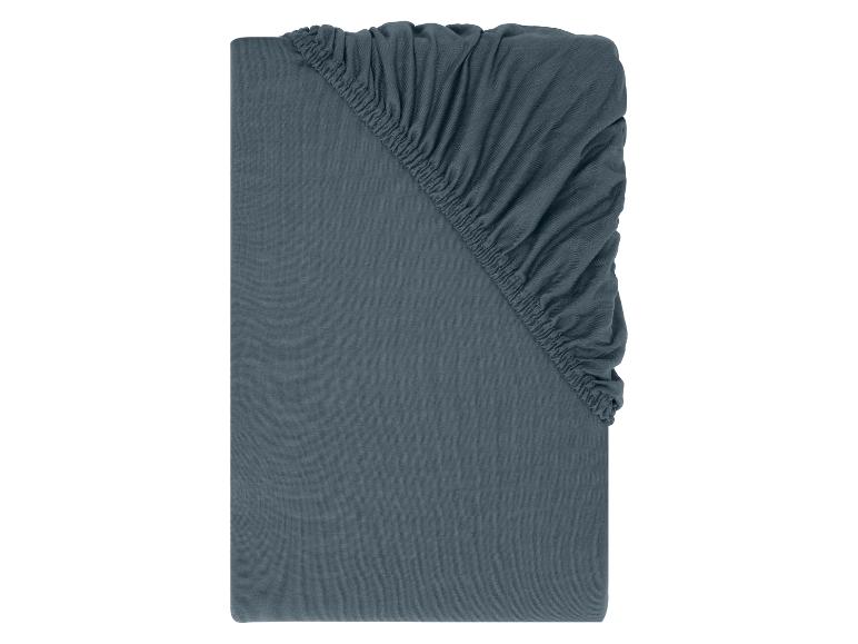 Drap-housse gris foncé avec élastique aux coins.