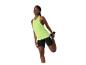 Femme en débardeur vert citron et short cycliste noir étirant sa jambe.