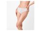 Femme en culotte de dentelle blanche posant les jambes croisées.