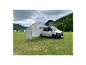 Volkswagen Transporter avec auvent et tente sur un camping.