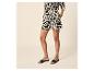 Femme en short et chemise à manches longues à motif abstrait noir et blanc.
