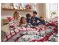 Famille en pyjamas de Noël assortis lisant un livre au lit.