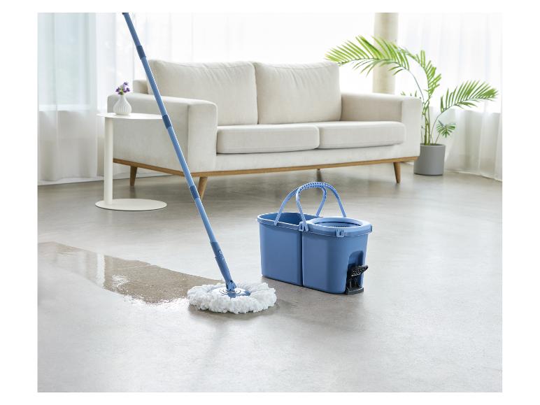 Dweil en emmer maken een vloer schoon in een woonkamer