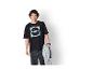 Homme en T-shirt noir avec logo Lidl et jean foncé, tenant un sweat à capuche gris.