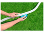 Een hand die een witte slang aansluit op een blauwe Intex zwembadpomp.
