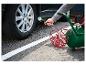 Homme gonflant un pneu de voiture avec un compresseur d'air et un manomètre.