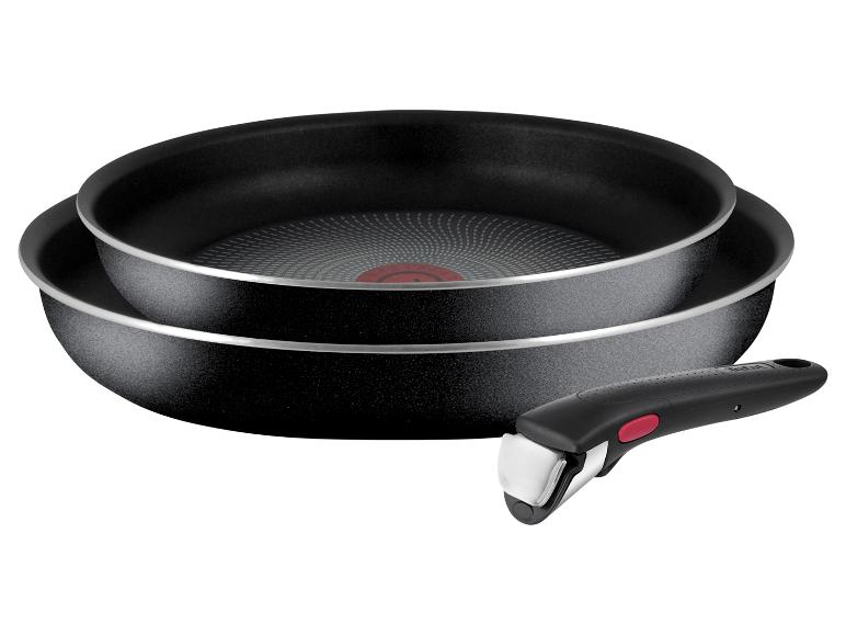 Deux poêles Tefal noires avec un bouton rouge sur la poignée.