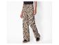 Pantalon large beige à imprimé léopard noir et baskets noires à semelle marron.