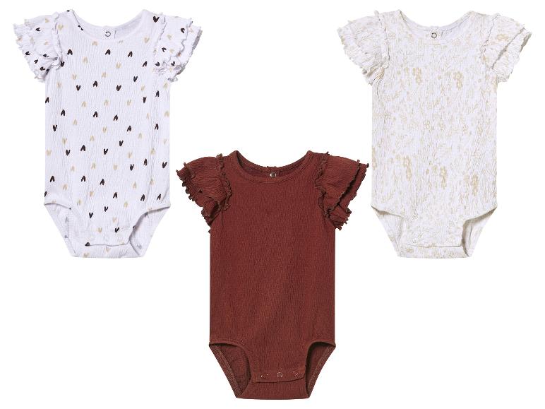 Trois bodys bébé à manches courtes : cœurs, fleurs et uni marron.
