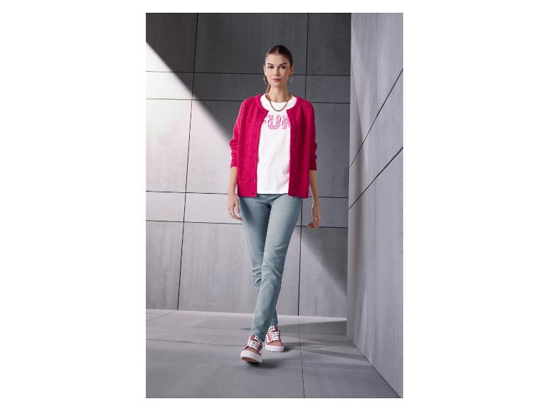 Femme en cardigan rose, t-shirt blanc avec 'FUN' et jean clair.
