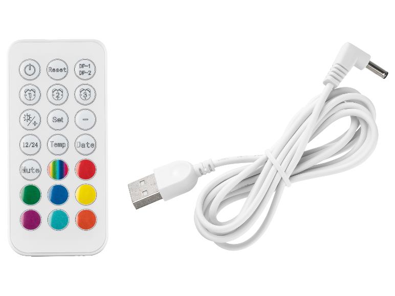 Télécommande blanche avec boutons colorés et câble de chargement USB.