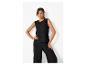 Femme en ensemble deux pièces noir, avec un haut sans manches et un pantalon large.