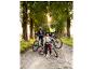 Familie op fietstocht: twee volwassenen en een kind met hun fietsen op een pad.