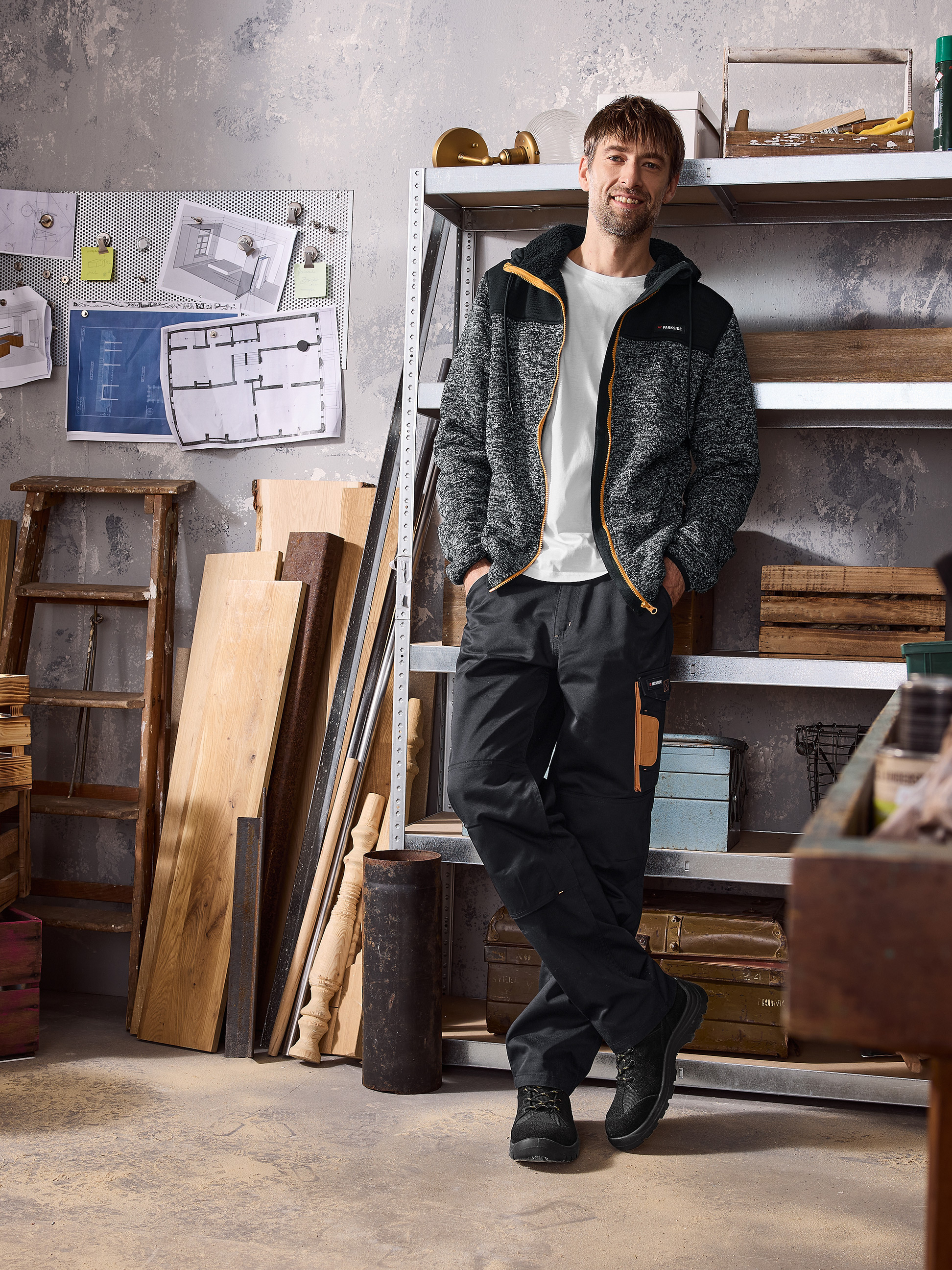 Man in Parkside hoodie en werkbroek in een werkplaats.