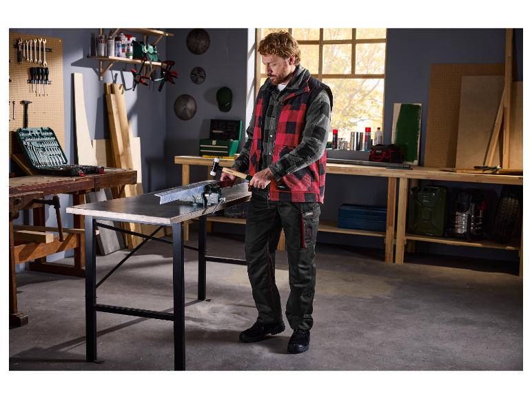 Homme dans un atelier utilisant un marteau en caoutchouc sur une pièce métallique dans un étau.