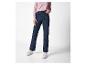 Een persoon draagt een roze shirt met lange mouwen, donkerblauwe jeans en witte sneakers.