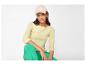 Femme en casquette beige, t-shirt jaune à manches longues et pantalon vert