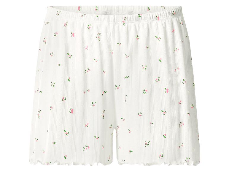 Short côtelé blanc avec un délicat motif floral rose et un ourlet volanté.