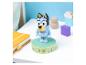 Figurine de chien bleu sur une base décorée, carnet jaune et blocs de bois.