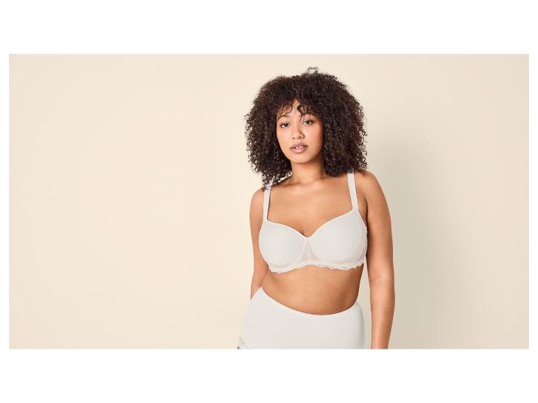 Femme aux cheveux bouclés en soutien-gorge et culotte blancs.