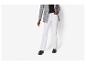 Femme en blazer blanc, pantalon noir et mocassins marron.