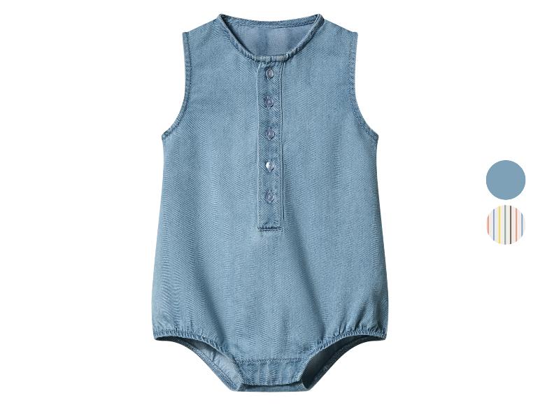 Barboteuse bébé en jean bleu clair avec boutons sur le devant et détails élastiques.