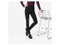 Femme en leggings noirs et haut violet, appuyée sur une chaise en grille métallique.