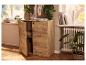 Meuble en bois avec portes ouvertes, plantes et livres dans un intérieur lumineux