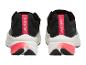 Een paar zwarte sportschoenen met roze en witte details, achteraanzicht.