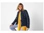 Femme porte une veste matelassée bleu foncé et une écharpe jaune.
