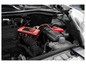 Een rode Jump Starter van het merk Ultimate Speed in de motorruimte van een auto.
