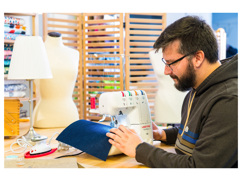 Un homme coud avec une machine à coudre Veritas Elastica II.