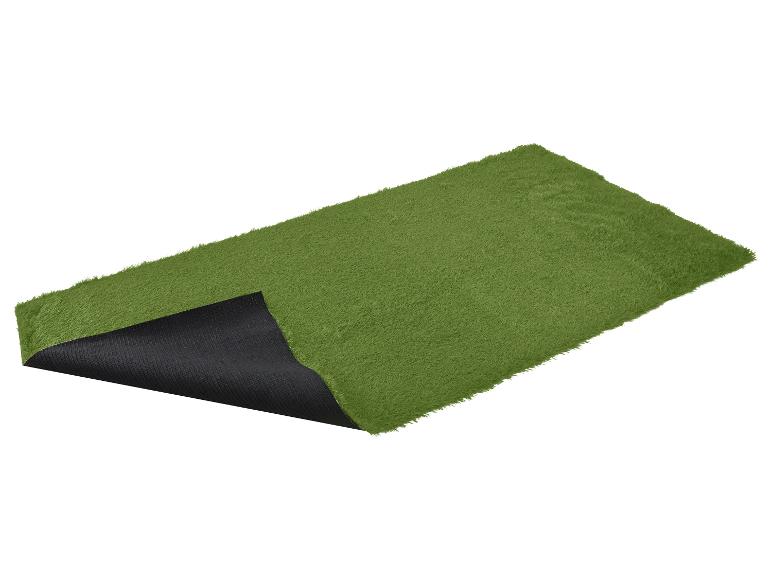 Rouleau de gazon artificiel vert avec le dessous noir visible.