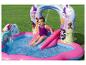Fille jouant sur un toboggan aquatique gonflable avec piscine, décoré de princesses.