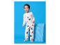 Blije jongen in witte pyjama met beermotief en sterrenprint.