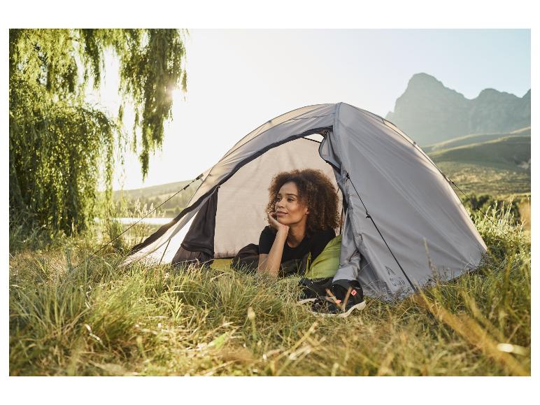 Vrouw ontspannen in een kampeertent.