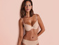 Une femme portant un soutien-gorge et une culotte beiges.