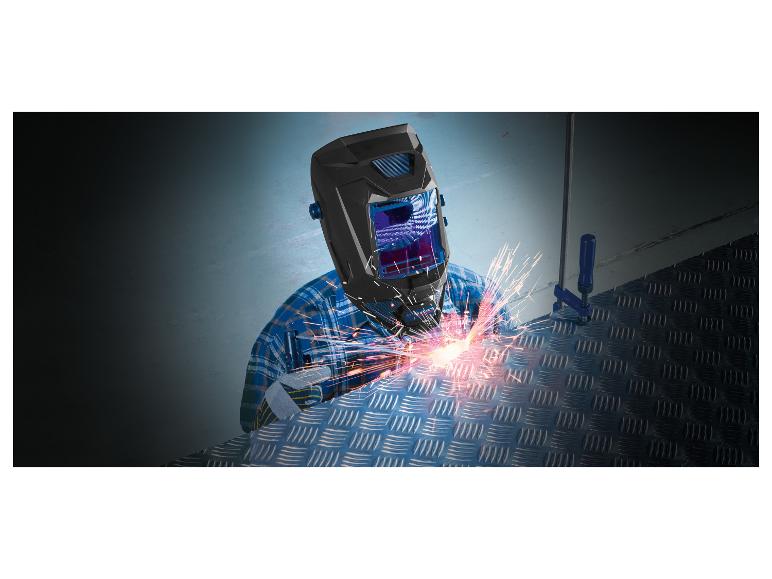 Un soudeur portant un masque de soudage effectue des travaux de soudage sur une plaque d'acier.