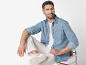 Man draagt jeans overhemd, beige broek en witte sneakers.